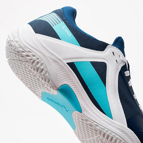 The Kanso Equilibrium EQx3 Unisex Badminton Shoes in navy showcase a mesh fabric with turquoise details. A textured sole offers stability and agility, while Speedlight foam boosts performance. The turquoise logo stands out against a plain white background, completing the sleek design.