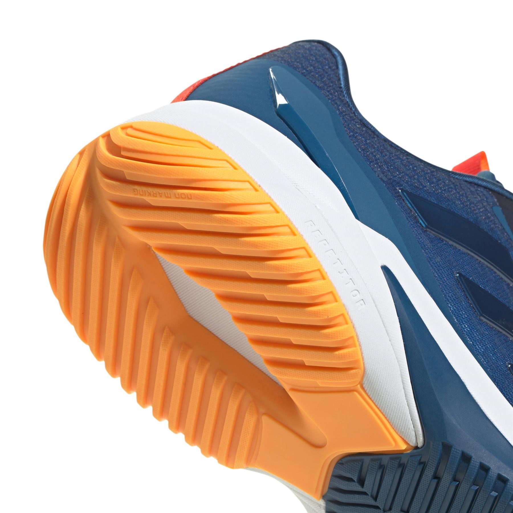 Close-up of the sole of ADIDAS Crazyflight 6 Men’s Indoor Badminton Shoes in navy, showcasing the orange and white textured, ribbed outsole that highlights the grip and tread pattern designed for court sports.