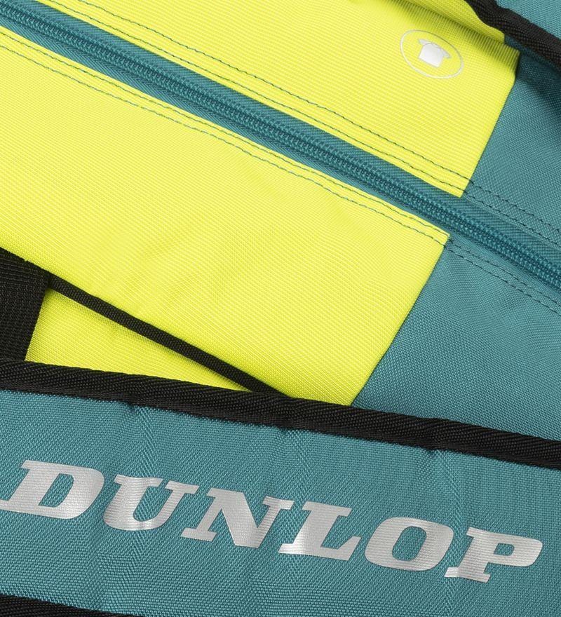 The Dunlop SX Performance 12 Racket Badminton Bag features a dual-color design in teal, black, and yellow. It prominently showcases the "Dunlop" logo on a teal strip, holds up to 12 rackets, includes padded shoulder straps for comfort, and has a circular cup-like icon near the zipper.