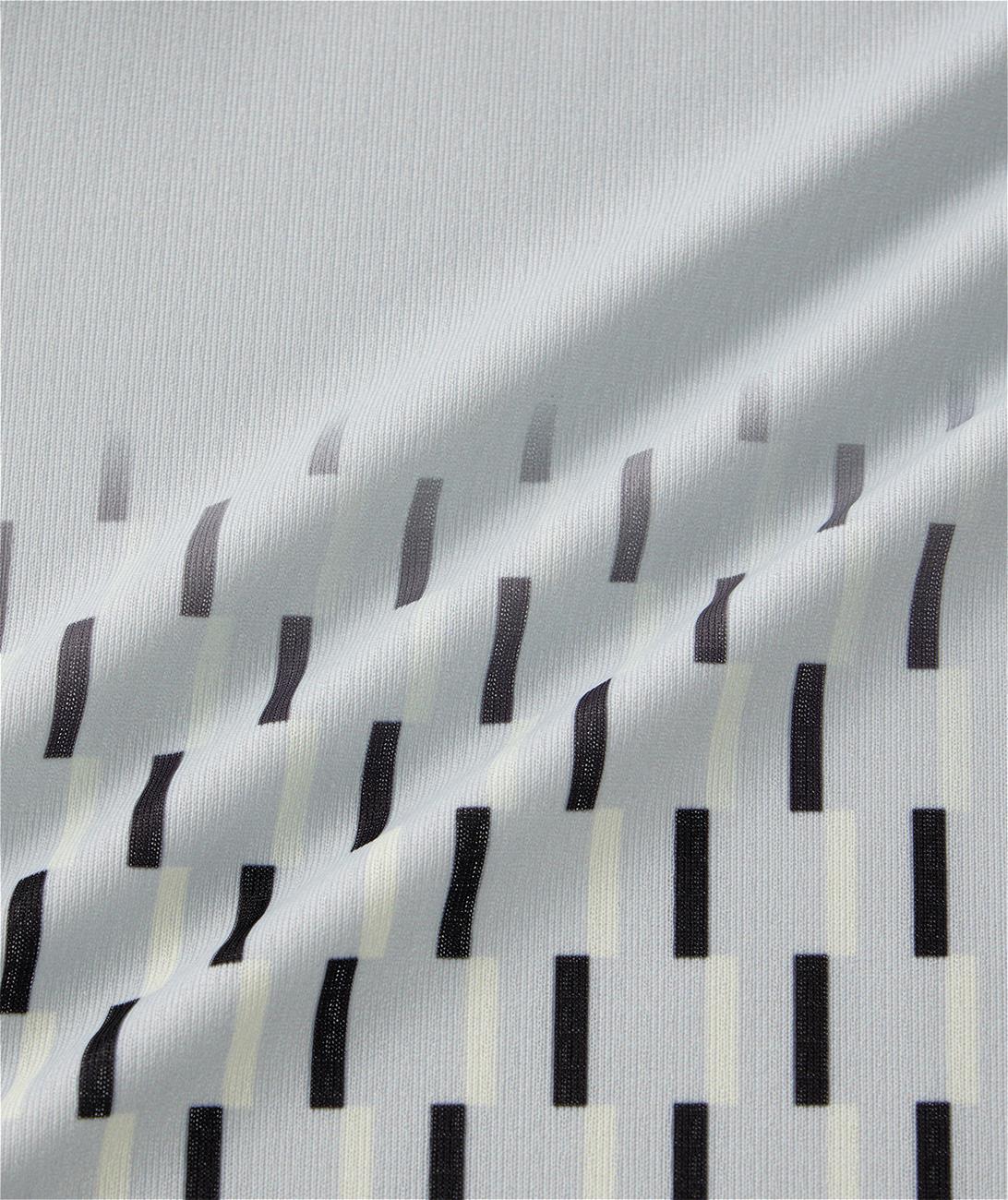 The Yonex 10713EX Crew Neck Men's Badminton T-Shirt in Silver Grey features light gray fabric with a subtle ribbed texture and staggered vertical black and off-white rectangular bars, offering stylish design and moisture-wicking comfort.