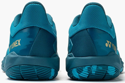 A pair of Yonex Power Cushion Cascade Drive 3 Unisex Badminton Shoes in peacock blue, viewed from the back, with textured soles, mesh uppers, and yellow Yonex logos on the heel.