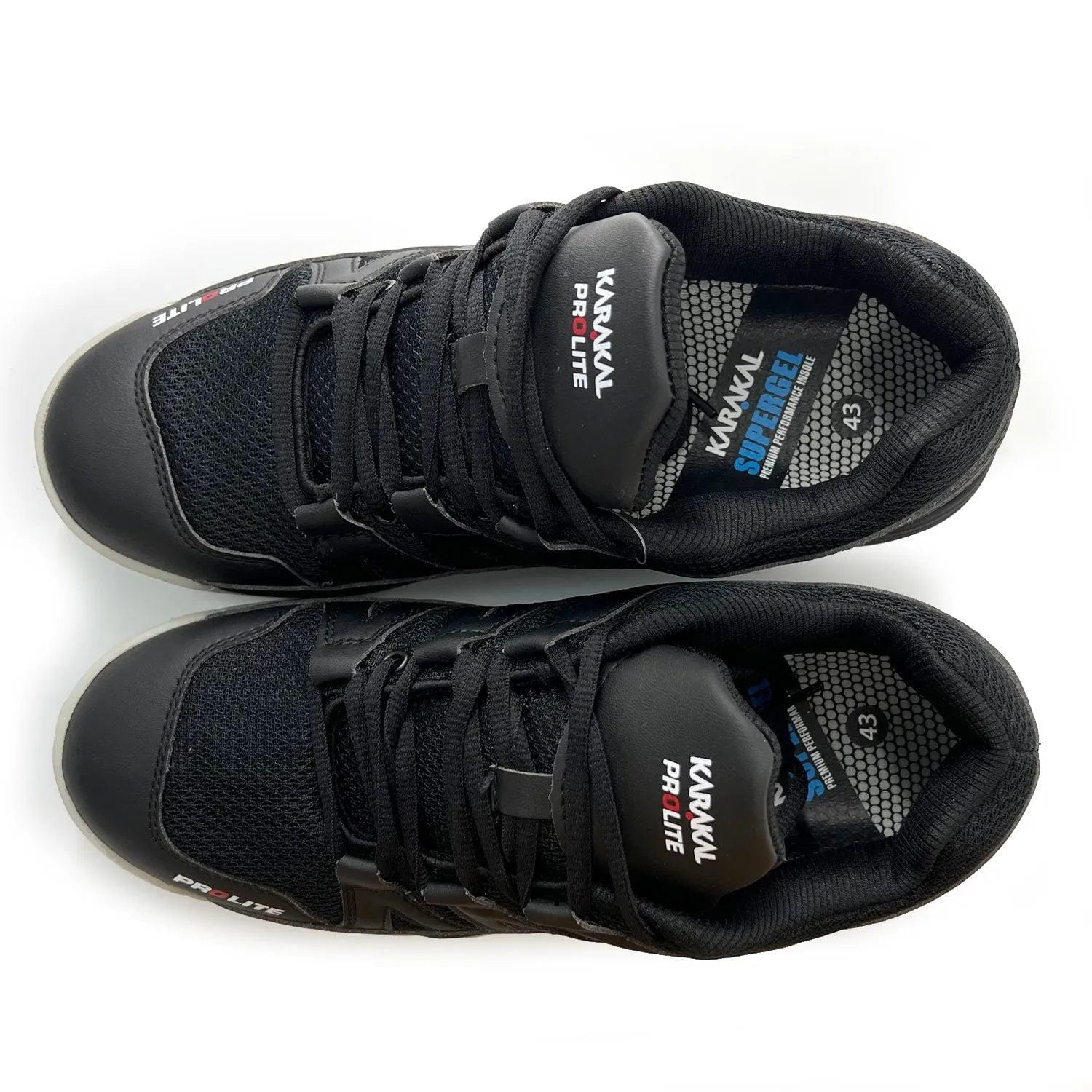 A pair of Karakal KF Pro Lite Badminton Shoes in new black, featuring mesh panels and shock-absorbing Gel Insoles, viewed from above. They come equipped with rubber soles for exceptional lateral stability, laces, and branding on the tongue with "SuperFlex" on the left shoe. Inner sole size: 43.