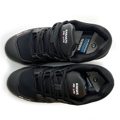 A pair of Karakal KF Pro Lite Badminton Shoes in new black, featuring mesh panels and shock-absorbing Gel Insoles, viewed from above. They come equipped with rubber soles for exceptional lateral stability, laces, and branding on the tongue with "SuperFlex" on the left shoe. Inner sole size: 43.