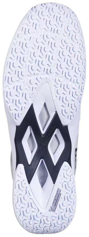 The image shows the white rubber sole of the Babolat Shadow Team 2 Men's Badminton Shoes, featuring a wavy tread and diamond-shaped cutouts in the center that reveal a black and gray underlayer.