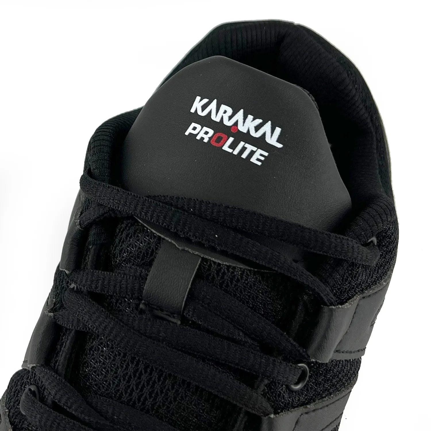 Close-up of a black Karakal KF Pro Lite Badminton Shoe, featuring the brand logo on the tongue. Ideal for badminton enthusiasts, this shoe boasts a textured mesh design with lace-up closure and lateral stability, complemented by a shock-absorbing gel insole for superior comfort and performance.