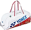 The Yonex 02631WEX Expert Tournament Badminton Bag in white features red accents, red handles, a blue Yonex logo, and a stylish red and gold base—perfect for tournaments.