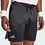 A person is wearing black adidas Climacool Ergo Pro Men’s Badminton Shorts, featuring an ergonomic cut, along with a light pink shirt and white wristbands. Only their lower torso and upper legs are visible as they stand with their hands by their sides.