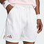 A person is shown from the waist to the upper legs, wearing white adidas Climacool Ergo Pro Mens Badminton Shorts and wristbands with their hands in their pockets, standing against a light background. The image highlights these quick-drying sports shorts from adidas, designed for both comfort and performance.