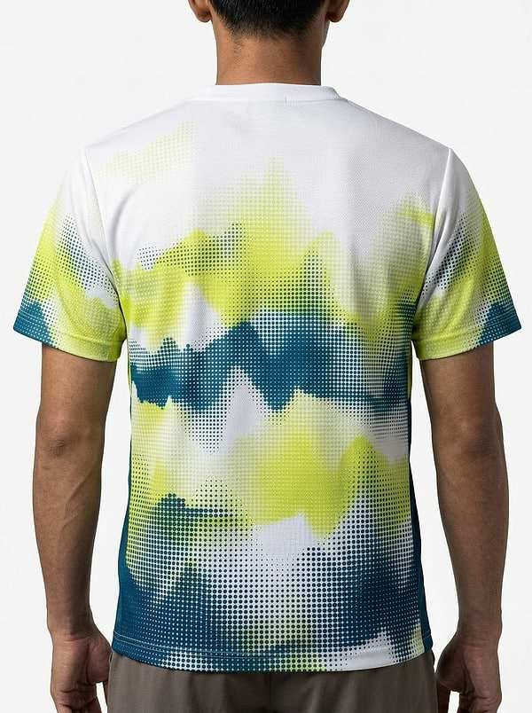 A person with short dark hair is seen from behind wearing a Yonex YTM2025A Mens Badminton T-Shirt - White by Yonex, showcasing a digital pixelated gradient design in yellow, green, blue, and white on performance fabric.