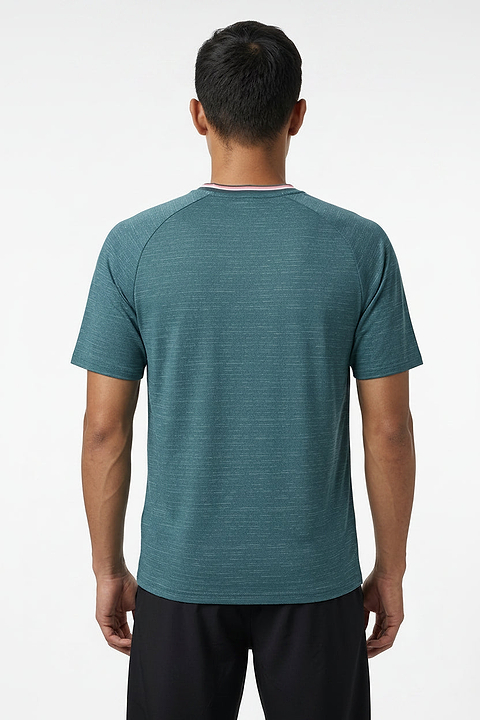 A man with short black hair stands with his back to the camera, wearing a K-Swiss Hypercourt Mens Melange 3 Badminton T-Shirt in Stargazer and black shorts against a plain white background.