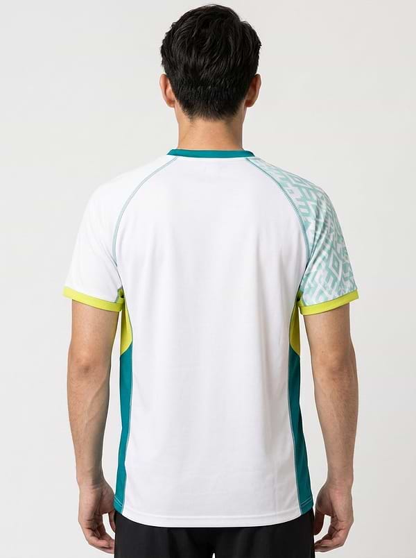 A man is seen from behind wearing the Yonex YTM11 Mens Badminton T-Shirt in white, featuring teal side panels, yellow accents, and a patterned teal and white section on one shoulder.