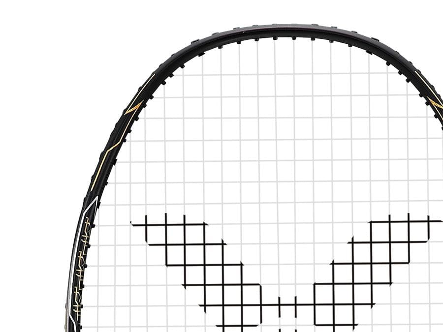 Close-up of a Victor Thruster F C badminton racket in a black and gold design on the strings. The top portion of the racket is visible, showcasing its sleek black frame and distinctive grid pattern, embodying the precision synonymous with Victor.