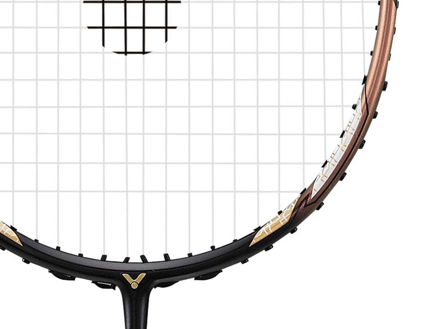 Close-up image of the Victor Thruster F C Badminton Racket's head, highlighting the strings and a portion of the frame with a sleek black and gold design, exemplifying the elegance of Victor badminton rackets.