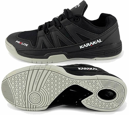 A pair of Karakal KF Pro Lite Badminton Shoes in black, featuring white soles and displaying the brand "Karakal" on the side. These lace-up shoes are equipped with a shock-absorbing gel insole and provide lateral stability with a textured grip pattern on the bottom for enhanced traction.