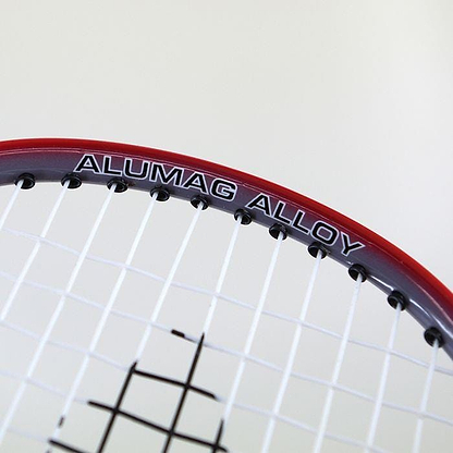 Close-up of the Karakal CB-2 Junior Badminton Racket's head featuring a red frame. The words "ALUMAG ALLOY" are printed on the aluminium head, and its strings create an isometric grid pattern.