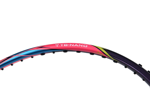 Close-up of a colorful Li-Ning Windstorm 74 badminton racket frame, prominently featuring the "TB-NANO" text that highlights its ultralight construction. The frame boasts vibrant colors of pink, blue, yellow, and black, though the strings are not visible.