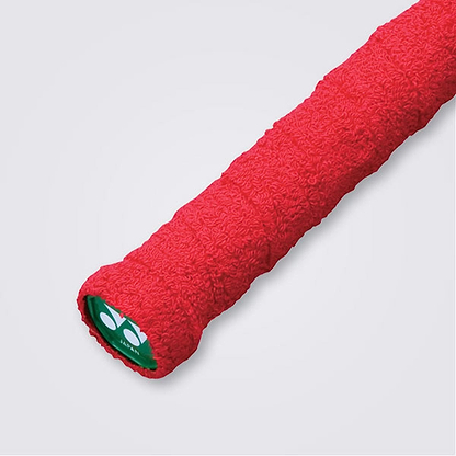 Close-up of the Yonex AC402EX Badminton Towel Grip in red on a sports racket handle against a white background. The absorbent material ensures a firm hold. The end cap is green with the Yonex logo in white.
