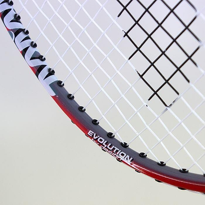 Close-up of the Karakal CB-2 Junior Badminton Racket, showcasing an isometric head for enhanced precision. The frame boasts a striking red color with black string holes, elegantly featuring "EVOLUTION" and "DESIGN" printed on it. Its tightly woven strings form a crisscross pattern, ideal for players seeking a perfect blend of style and performance.