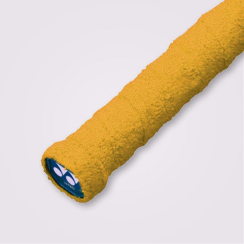 Close-up of the Yonex AC402EX Badminton Towel Grip in yellow, showcasing its textured surface designed for enhanced absorbency and a blue end cap displaying the white Yonex logo. Crafted from 100% cotton, it ensures your grip stays dry. The background is a plain light gray.