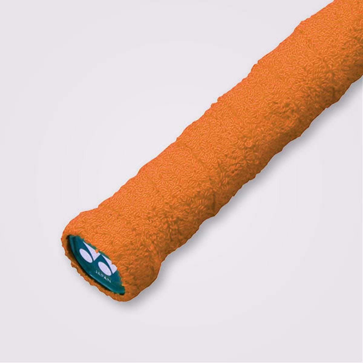 Close-up of an orange Yonex AC402EX Badminton Towel Grip for a sports racket against a white background. The 100% cotton grip features a wavy pattern and an end cap with a logo displaying two white shapes on a green background, offering excellent absorbency.
