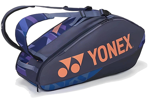 The Yonex 92426EX 6 Racket Pro Tennis Bag in Midnight Navy holds up to 6 rackets and features two shoulder straps for easy carrying, with a bold orange logo and geometric blue accents for a sporty look.