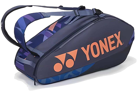 The Yonex 92426EX 6 Racket Pro Tennis Bag in Midnight Navy holds up to 6 rackets and features two shoulder straps for easy carrying, with a bold orange logo and geometric blue accents for a sporty look.