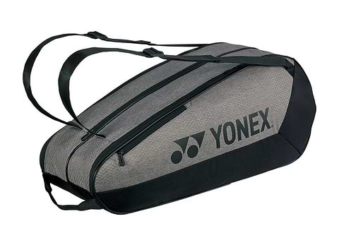 The Yonex 42526EX Team 6 Racket Badminton Bag in grey and black, shown from the side with the Yonex logo across the main compartment and a padded shoulder strap.