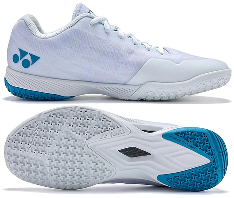 The Yonex Power Cushion Aerus Z2 Men's Badminton Shoes in White/Blue feature a mesh upper, cushioned Power Cushion sole, textured outsole, and Aerus Z2 branding on the heel, shown from the side and bottom.