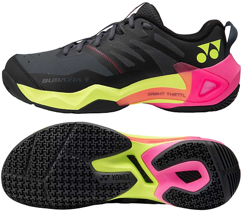 The Yonex Subaxia GT Men's Badminton Shoes in dark grey feature bold patterns, neon yellow and pink accents, the Yonex logo, and advanced GRPHT THRTTL technology for enhanced performance, shown from both side and sole views.