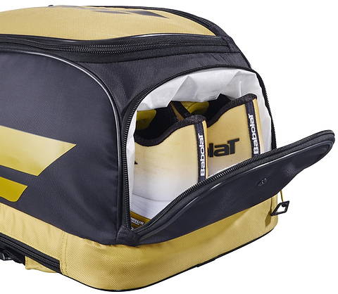 A Babolat Backrack 3 Badminton Bag in black and yellow by Babolat sits with its side pocket open, showing two tennis racquet handles inside.