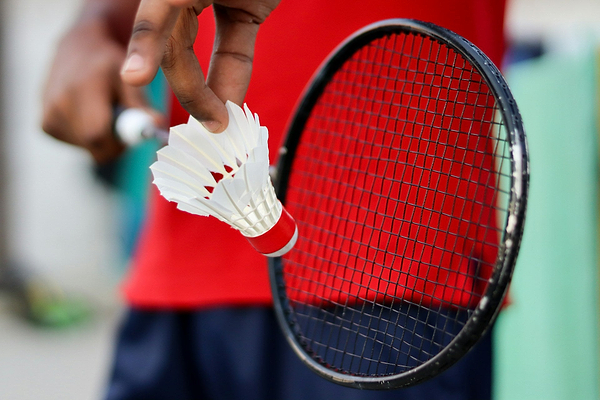 Shuttlecock being held before a serve at the start of a point