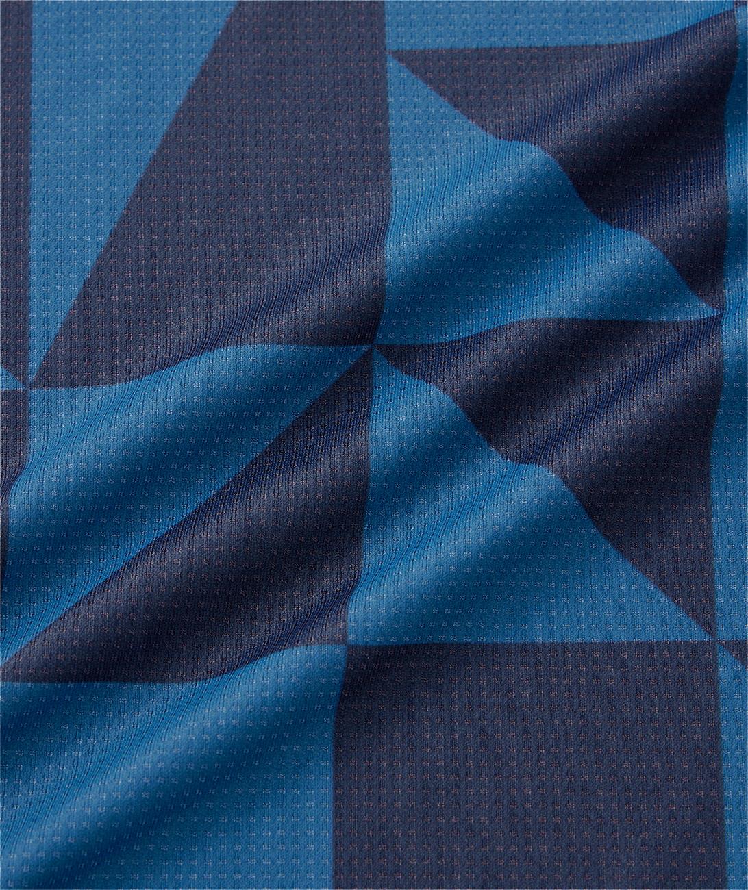 Close-up of the Yonex 10712YX Crew Neck Men's Badminton T-Shirt in Indigo Blue, featuring wavy, textured navy and blue geometric patterns with diagonal lines and dotted details on quick-drying fabric.