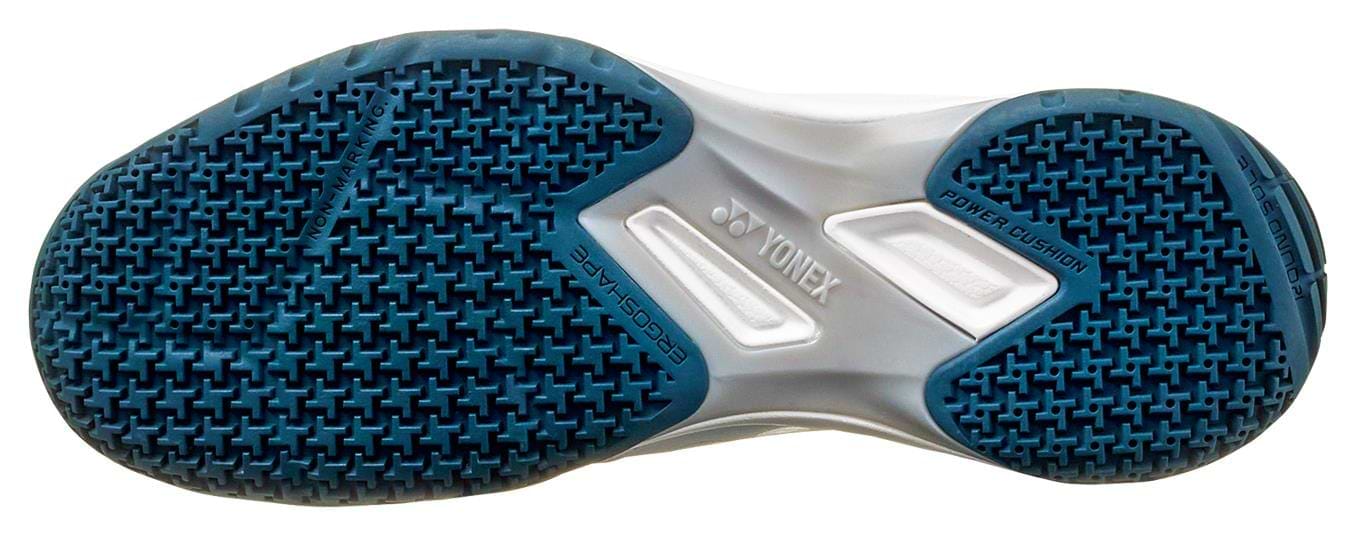 The image shows the tread of a Yonex Power Cushion 65X4, featuring a blue textured pattern. Equipped with "Power Cushion" and "Hexagrip," it enhances grip and cushioning, boosting comfort and performance while reducing fatigue.