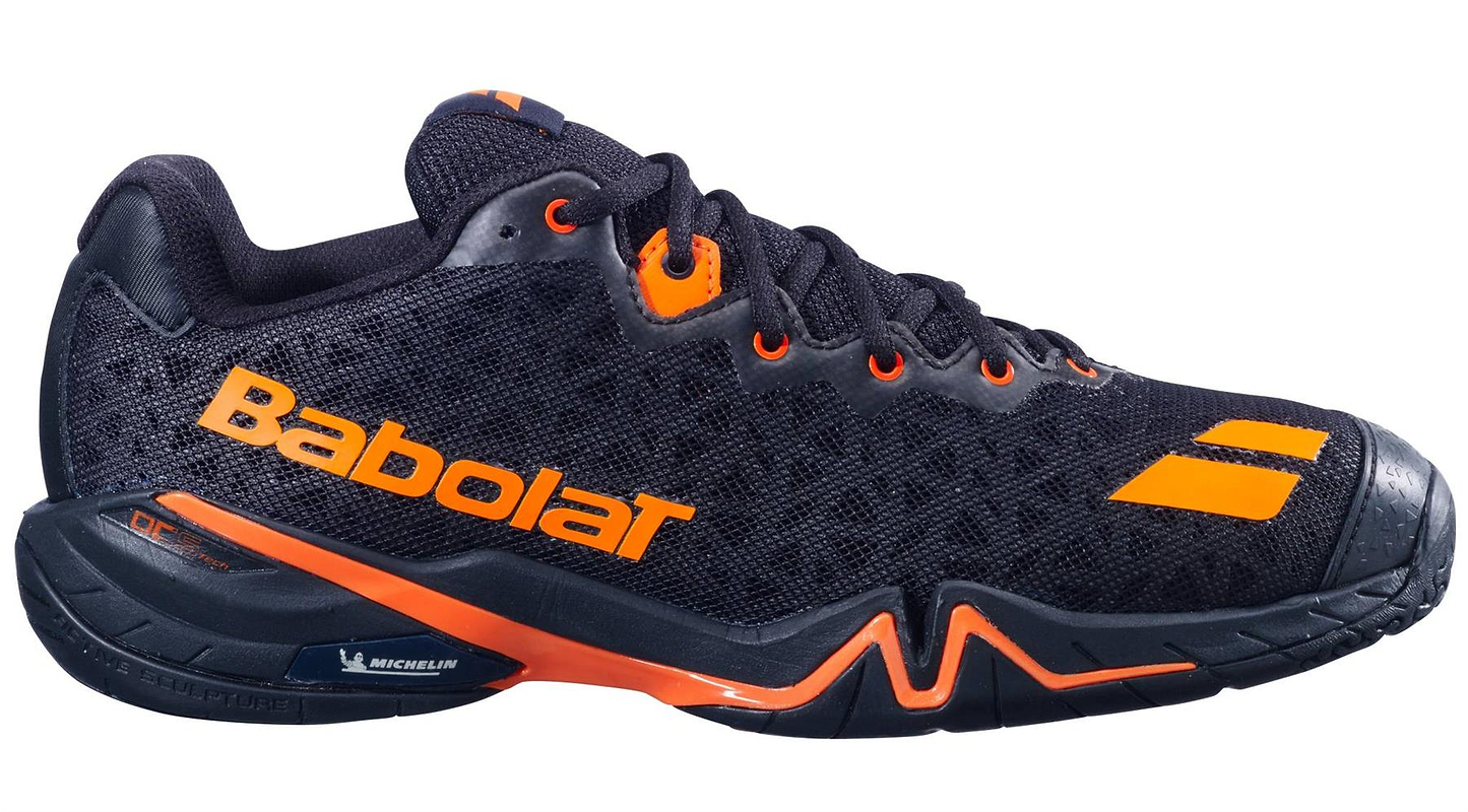 The Babolat Shadow 4 Men's Badminton Shoes in black with vivid orange accents are shown on a white background.