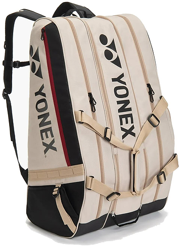 The Yonex BA726212EX Gearlogic 12 Racket Badminton Bag in beige features black accents, red zippers, multiple compartments for up to 12 rackets, adjustable straps, and the Yonex logo on the front and side.