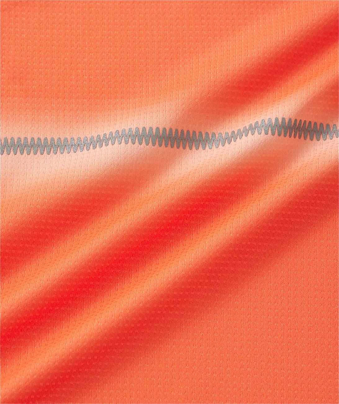 Close-up of the vibrant Cyber Orange fabric on the Yonex 10711YX Crew Neck Men's Badminton T-Shirt, showing its textured grid pattern and a gray zigzag stitch, with gentle light highlighting Yonex quality.