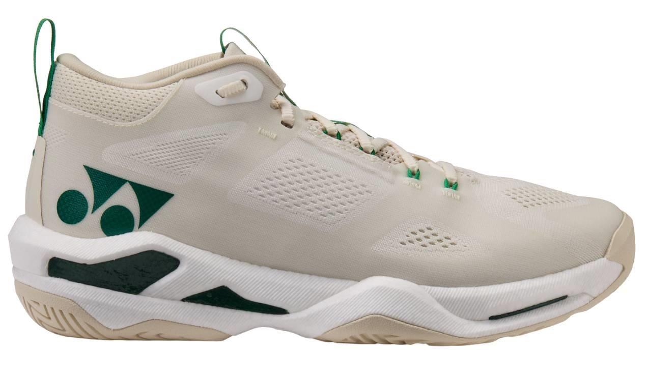 The Yonex Power Cushion GRPHT THRTTL Concept men's badminton shoe features a beige mid-top design with green accents, mesh panels for breathability, a stylized side logo, and a textured sole.