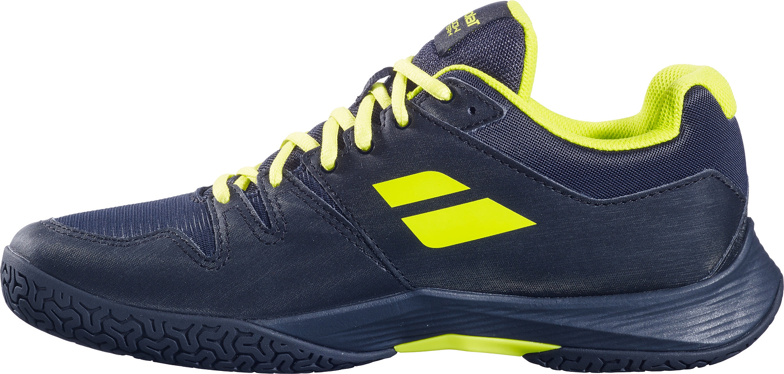 A pair of Babolat Shadow Team 2 Men's Badminton Shoes in black with lime accents, including lime laces, a lime interior, and lime logo details, is shown from the side on a white background. Designed by Babolat as premium indoor court shoes, these badminton shoes offer a durable Michelin outsole for superior traction and performance.