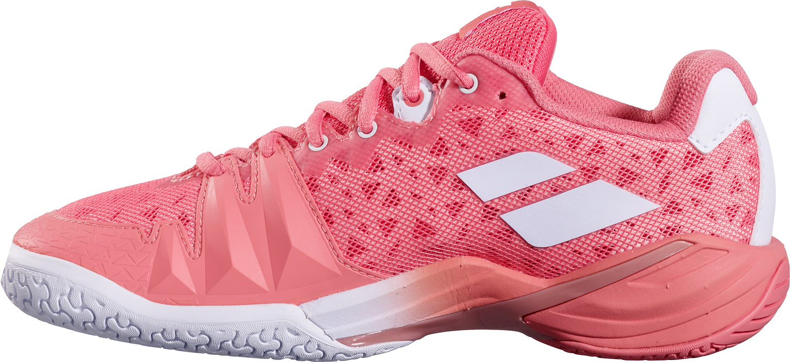 The Babolat Shadow 4 Womens Badminton Shoes in Shell Pink and White feature a stylish pink design with white accents and geometric side patterns, providing a textured sole for advanced players who want enhanced stability on the court.