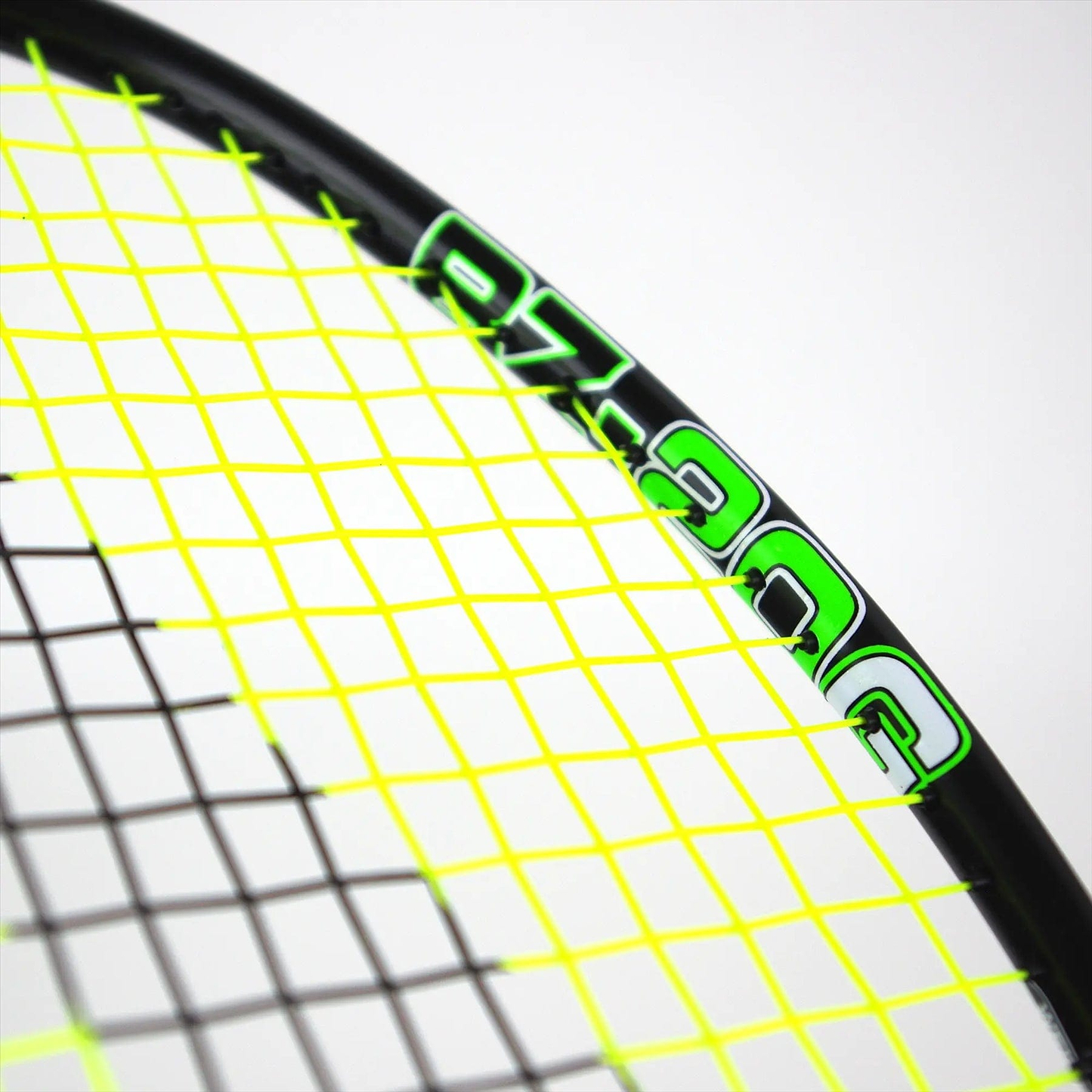Close-up of a Karakal Black Zone BZ 20 2.1 badminton racket featuring a black frame with neon yellow strings, green lettering, and "97" partially visible against a light gray background.