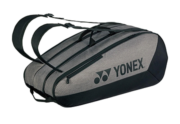 The Yonex 42529EX Team 9 Racket Badminton Bag, in gray and black, features dual shoulder straps and a prominent side logo. Its sleek, elongated design offers high capacity with multiple compartments for carrying sports gear such as rackets.