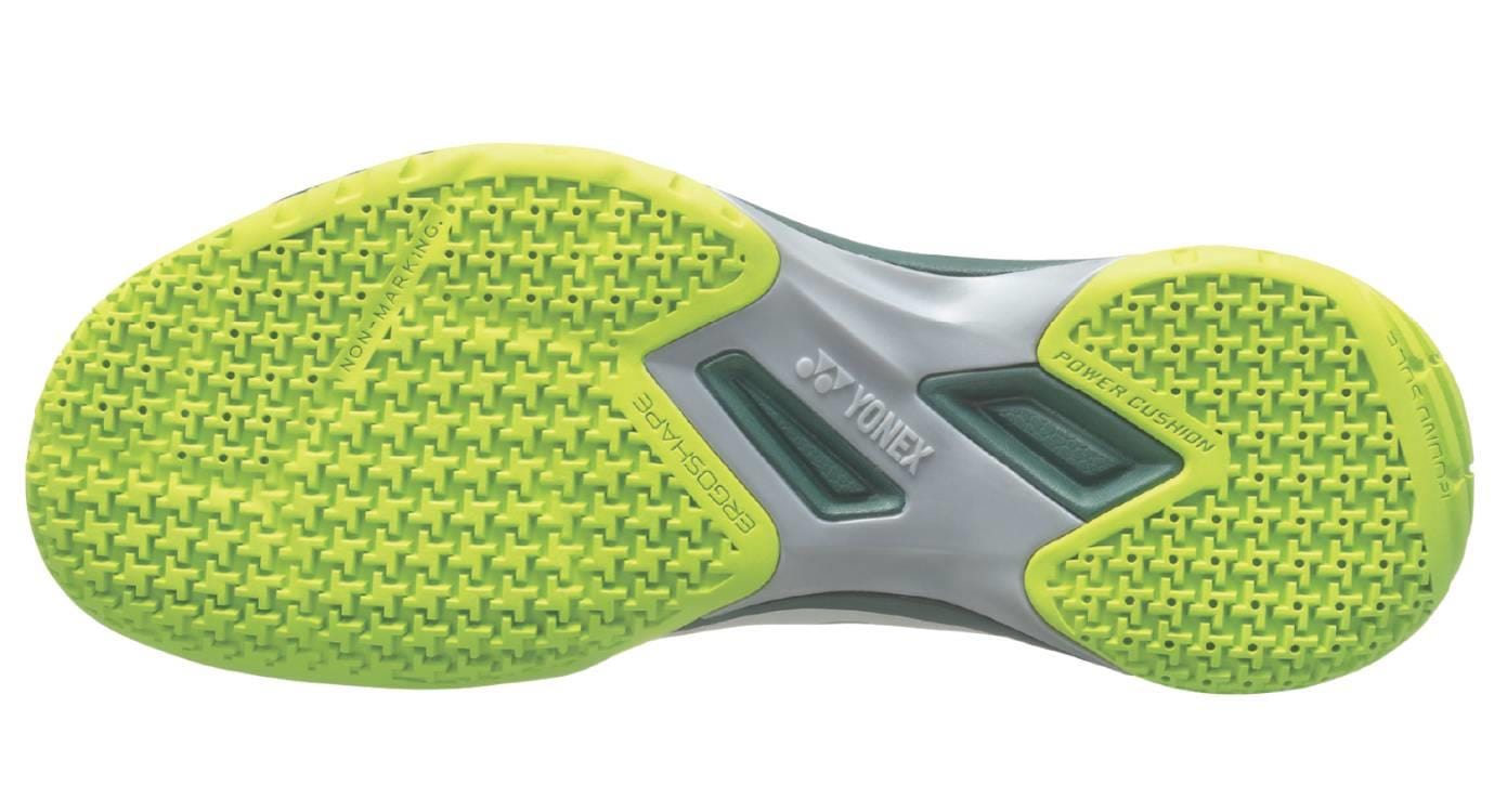The image shows the sole of Yonex Power Cushion 65X4 Viktor Axelsen Badminton Shoes (White/Lime) with a bright lime tread and cross pattern for grip. The gray midsection has "Yonex" and "Ergoshape" branding.