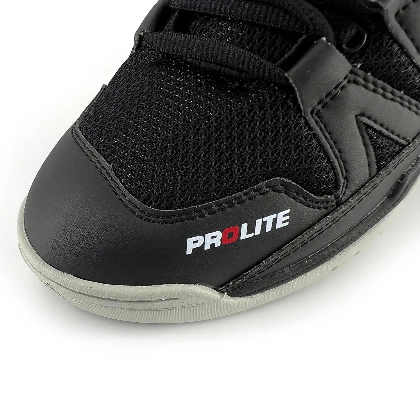 The Karakal KF Pro Lite Badminton Shoes in New Black showcase a close-up of their front, combining mesh fabric with a leather-like material. The shoe is designed for lateral stability and prominently displays "PROLITE" in white and red on the side. It features visible black laces and detailed stitching. The light gray sole is equipped with a shock-absorbing gel insole to enhance comfort.