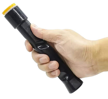 A hand holds the BadmintonHQ Badminton Grip Correction Trainer—a black, cylindrical tool with an orange-tinted lens—against a white background, demonstrating proper grip technique for badminton practice.