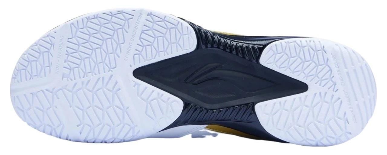 The image displays the white and black high-traction outsole of Li-Ning Blast JF-01 Lite Unisex Badminton Shoes, featuring a geometric tread pattern, textured grip, and a unique central black logo-shaped design for superior traction.