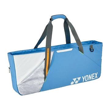 The Yonex 52531EX Club Tournament Badminton Bag in Grayish Blue has gray straps, a zippered front pocket with silver metallic and white design, a sleek rectangular shape with a racket divider for organizing equipment, and a separate shoe compartment for added convenience.