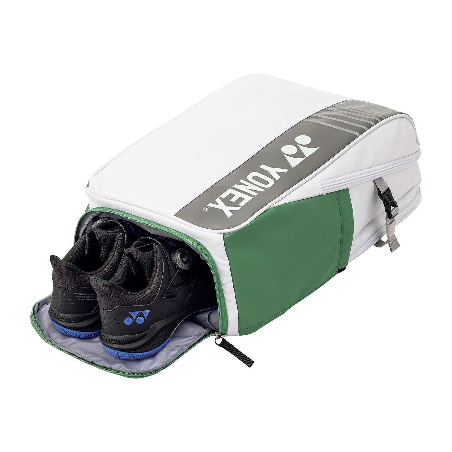 A Yonex 52512EX Club Badminton Backpack - White, featuring green and gray panels with the Yonex logo on top, is partially unzipped to reveal a pair of black and blue badminton shoes.