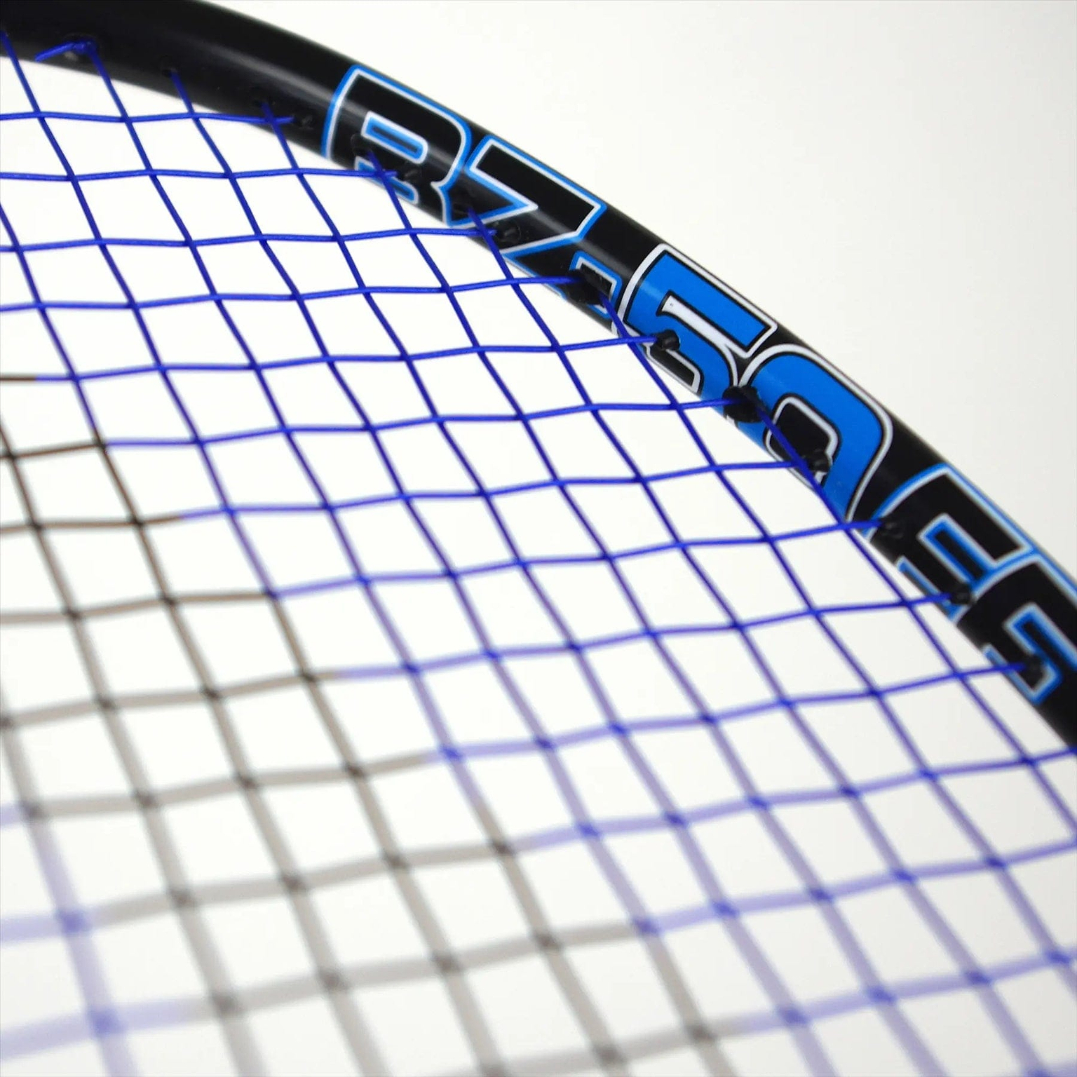 Close-up of the Karakal Black Zone BZ 50 2.1 Badminton Racket head showcasing blue strings on a black frame with "RZ-50FG" text. Made from Fast Fibre Graphite, the isometric square head offers precision, and tightly woven strings stand out against a plain white background.
