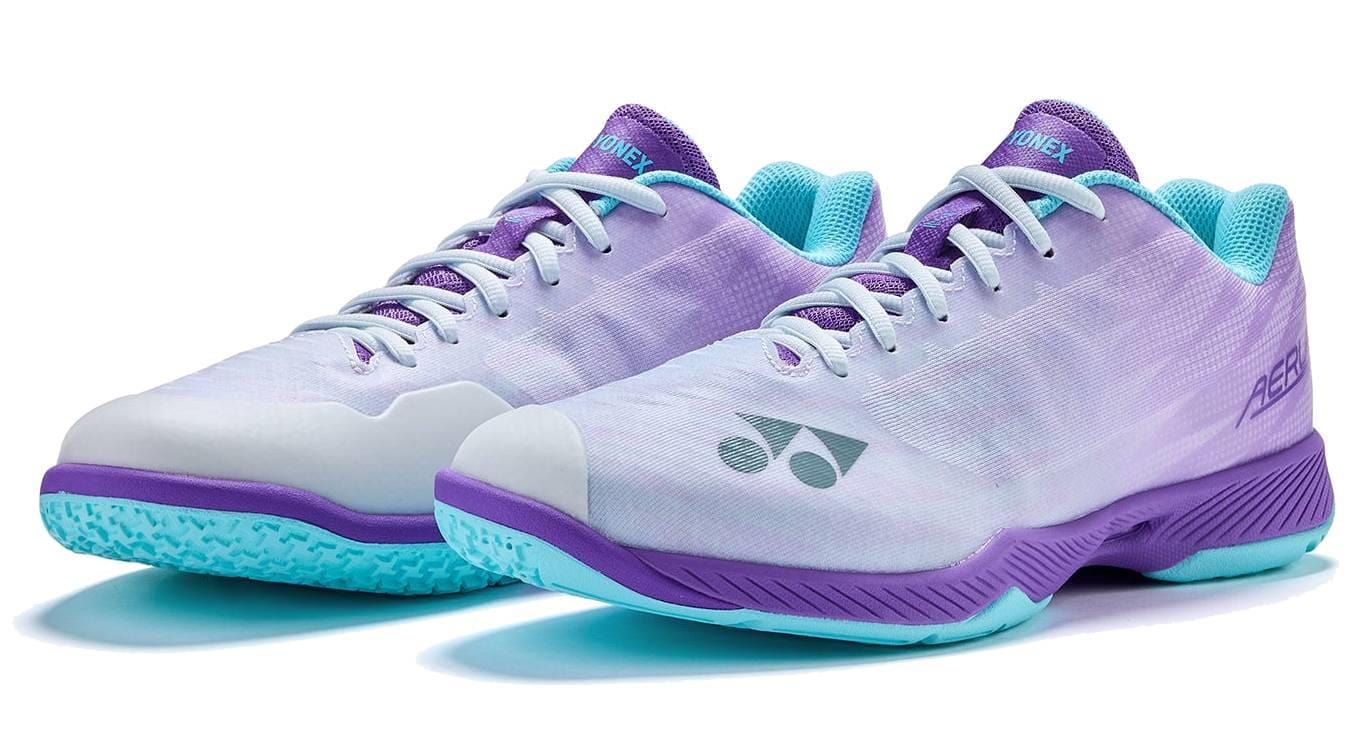 The Yonex Power Cushion Aerus Z2 Wide Men's Badminton Shoes in indigo offer a comfortable wide fit, teal outsoles, and advanced Power Cushion technology, with the Yonex logo on the side and stylish purple and teal accents.