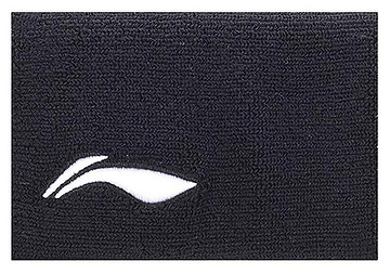 The Li-Ning Corner Logo Wristband in black features a textured fabric with a small, white, stylized leaf or wing logo on the lower left. It provides superior perspiration control ideal for badminton players.